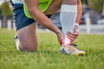Piłkarz trzyma się za bolące ścięgno. Zerwanie ścięgna Achillesa — przyczyny, objawy i sposoby zapobiegania