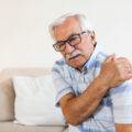 Starszy mężczyzna trzyma się za bolący bark. Protezoplastyka stawu barkowego - od czego zależy rodzaj stosowanej protezy