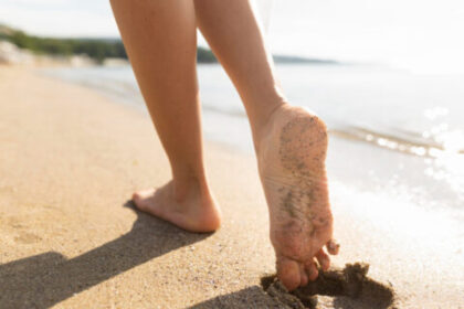 Kobiece stopy na piasku. Czym jest opadająca stopa